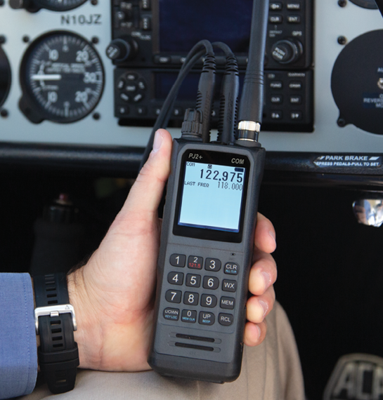 PJ2+ COM Radio displayed being held in hand within plane